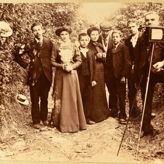 Groupe posant avec un photographe et son appareil, 1900